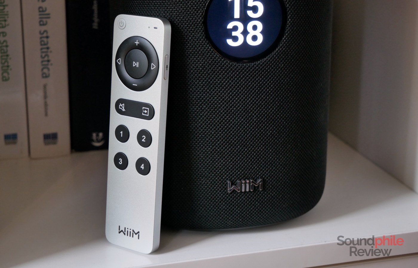 A picture of the remote sitting against the WiiM Sound